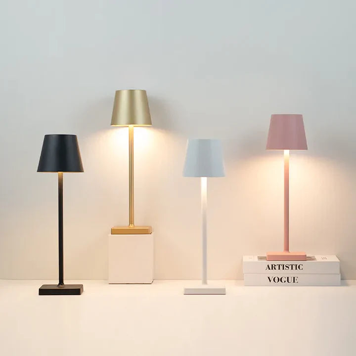 Four table lamps with different colored shades on a light gray background